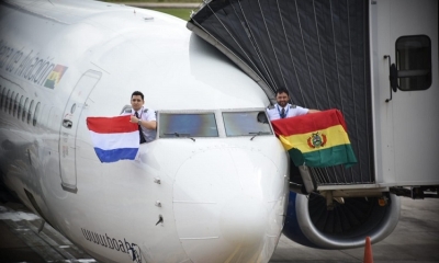 Los pilotos de BoA sostienen las banderas de Paraguay y Bolivia.