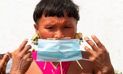 Un indígena yanomami sostiene una mascarilla en Alto Alegre (Brasil). | Fuente: EFE