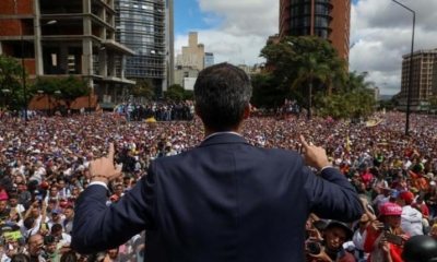 El presidente del Parlamento venezolano, Juan Guaidó, saluda a manifestantes tras anunciar que asume las competencias del Ejecutivo.