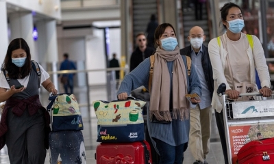 Viajeros con mascarilla para evitar contagios por coronavirus chino, en el aeropuerto Hong Kong.
