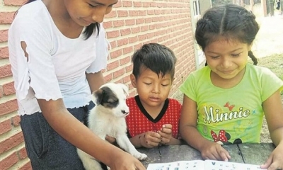 No tienen celular Flavia Andrea enseña a leer a sus hermanos Claudia y Santi Rodrigo.