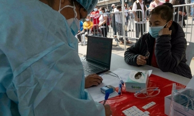Una mujer espera que le hagan un hisopado para COVID-19 en un centro de salud ambulante en una calle del centro de Lima.