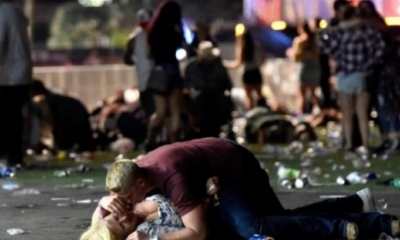 Un hombre cubre con su cuerpo a una mujer que yace en el suelo tras el tiroteo en Las Vegas