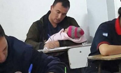 El bombero rindiendo con su hijita de dos meses. Foto: RRSS