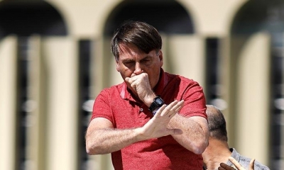 El presidente brasileño Jair Bolsonaro tose durante un acto público, el domingo. | EFE