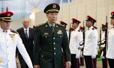 El ministro de Defensa de China, General Li Shangfu, seguido por su homólogo de Singapur, Ng Eng Hen, pasan revista a la guardia de honor