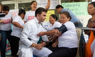 Un médico atendiendo a una autoridad municipal en la protesta en puertas de la gobernación.