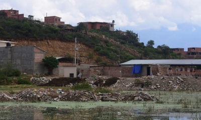 Escombros que se usan para rellenar la laguna rodeados de agua