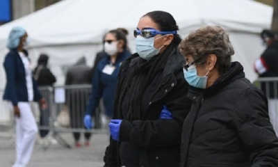 Personas con mascarillas afuera del Hospital Central de Brooklyn, donde se instaló una carpa para atender casos de coronavirus. | Fuente: AFP