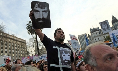 Un hombre muestra una fotografía de Santiago Maldonado durante una manifestación en Buenos Aires para reclamar su búsqueda