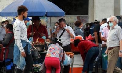 Varias personas sin barbijos o con su uso indebido caminan por una concurrida calle en Santa Cruz | EFE