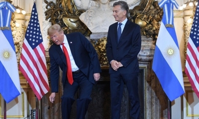Momento en el que Trump deja en el piso el aparato electrónico ante la mirada de su par argentino