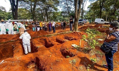 Empleados del servicio funerario entierran a una víctima de la Covid-19 este jueves, en el cementerio de Vila Formosa, en São Paulo. | EFE