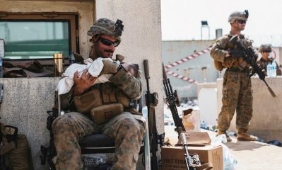 El niño rescatado en manos de uno de los marines. Foto: AFP.