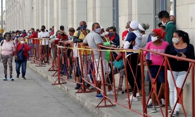 Imagen de archivo que muestra a personas con tapabocas haciendo fila para comprar alimentos en un mercado de La Habana.
