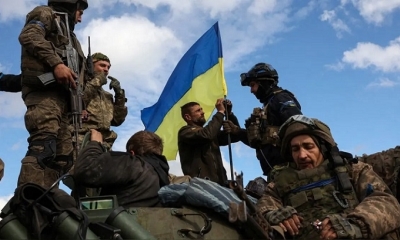Soldados ucranianos ajustan una bandera nacional sobre un vehículo blindado de personal en una carretera cerca de Lyman, región de Donetsk