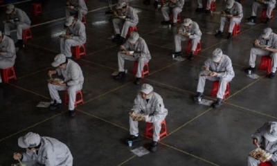 Trabajadores en un fábrica de Wuhan almuerzan respetando el aislamiento social. | Fuente: EFE