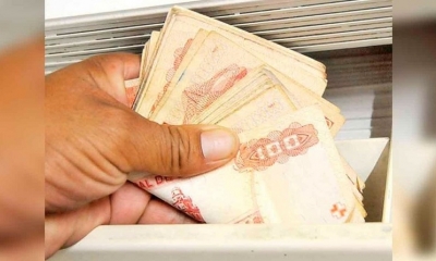 Imagen referencial de una persona que cuenta dinero. 