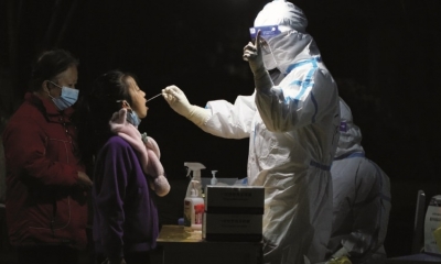Personal sanitario realiza un hisopado a una niña en la ciudad china de Xi’an.