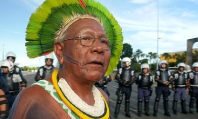 El jefe indígena Paulinho Paiakan parado frente a la policía antidisturbios durante una movilización indígena nacional en Brasil. | Fuente: AFP