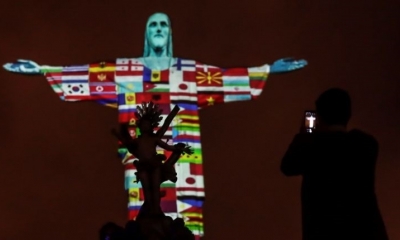 Las banderas de los países afectados por el coronavirus son proyectadas en la estatua de Cristo Redentor