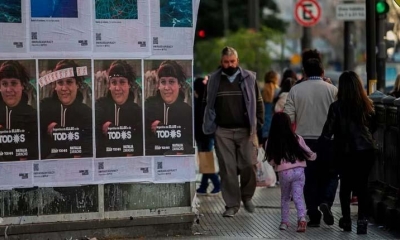 Transeúntes en medio de paredes cubiertas con publicidad electoral en Buenos Aires, Argentina. | EFE