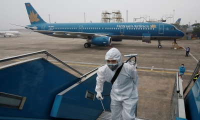Un trabajador de la salud rocía desinfectante dentro de un avión de Vietnam Airlines durante el brote de coronavirus, en el aeropuerto de Noi Bai 