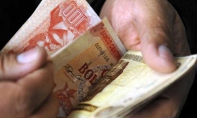 Una persona cuenta dinero en una entidad financiera. Foto: archivo