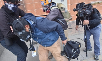 Los periodistas Santiago y Sergio Limachi tras ser gasificados son auxiliados. 