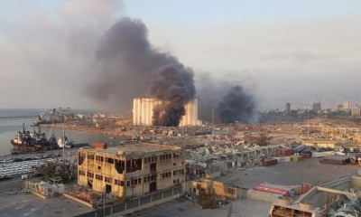 Una imagen realizada con un teléfono móvil que muestra una vista general de la zona del puerto con humo saliendo de un área de una gran explosión. 