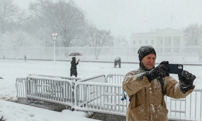 Un turista se anima a pasear pese a la nevada, frente a la Casa Blanca en Washington.