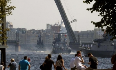 La gente mira como los buques de guerra de la Armada rusa asisten a un ensayo para el desfile del 