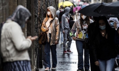 Varias personas con mascarillas caminan en Italia.