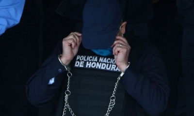 El expresidente hondureño Juan Orlando Hernández se ve esposado en la sede de la Policía de Honduras. Foto: AFP.