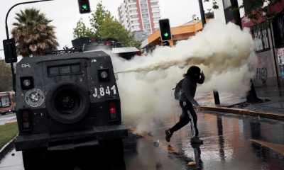 Un manifestante huye de los gases lacrimógenos durante los enfrentamientos con la Policía en Chile, el 19 de octubre de 2019. 