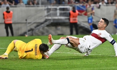 Cristiano Ronaldo de Portugal comete una falta sobre Martin Dubravka de Eslovaquia durante el partido de clasificación de la Eurocopa 2024.