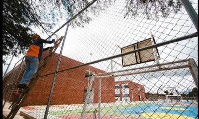 Funcionarios arreglan la malla de la cancha polifuncional en el colegio Hernando Siles
