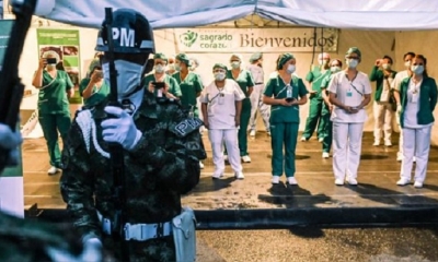 Enfermeras colombianas observan cómo los soldados les rinden homenaje en el Día Internacional de la Enfermera, en la ciudad de Medellín. 