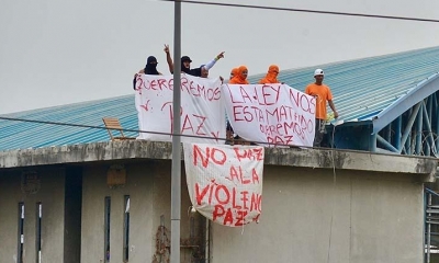 Presos muestran sábanas con mensajes en las azoteas del Centro de Privación de la Libertad Zonal, en Guayaquil (Quito). 